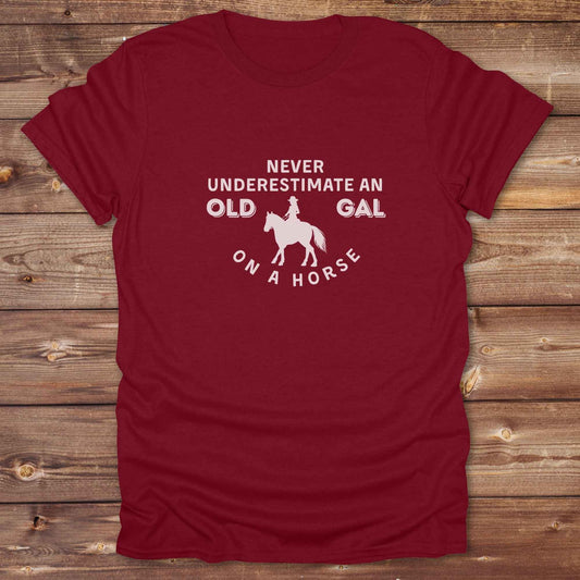 Fun western t-shirt for horse lovers and cowgirls. Western cowgirl graphic tee with horse design. Cowboy humor t-shirt for rodeo and country lovers. Horse lover funny t-shirt with western theme. Country style horse graphic tee for cowboys and cowgirls. Retro style funny western shirt for equestrians. Cute and funny country shirt with horse print. Southern cowgirl funny quote shirt for horse lovers. Never underestimate an old gal on a horse.