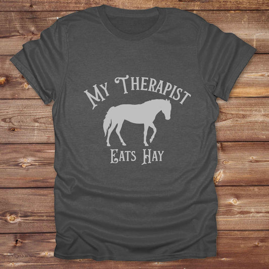 “My Therapist Eats Hay” t-shirt is the perfect mix of humor and horse lover pride, made for cowgirls, cowboys, and western enthusiasts alike. Featuring a bold horse silhouette and vintage western font, it’s ideal for barn days, rodeo nights, or gifting to someone who finds peace in the pasture. Great for birthdays, country events, or just repping your equine therapist with style. Whether you ride for fun or sanity, this western tee keeps the cowboy spirit alive with every wear.
