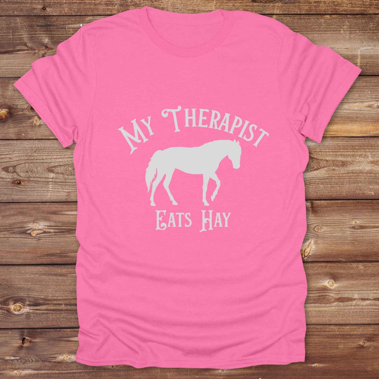 “My Therapist Eats Hay” t-shirt is the perfect mix of humor and horse lover pride, made for cowgirls, cowboys, and western enthusiasts alike. Featuring a bold horse silhouette and vintage western font, it’s ideal for barn days, rodeo nights, or gifting to someone who finds peace in the pasture. Great for birthdays, country events, or just repping your equine therapist with style. Whether you ride for fun or sanity, this western tee keeps the cowboy spirit alive with every wear.