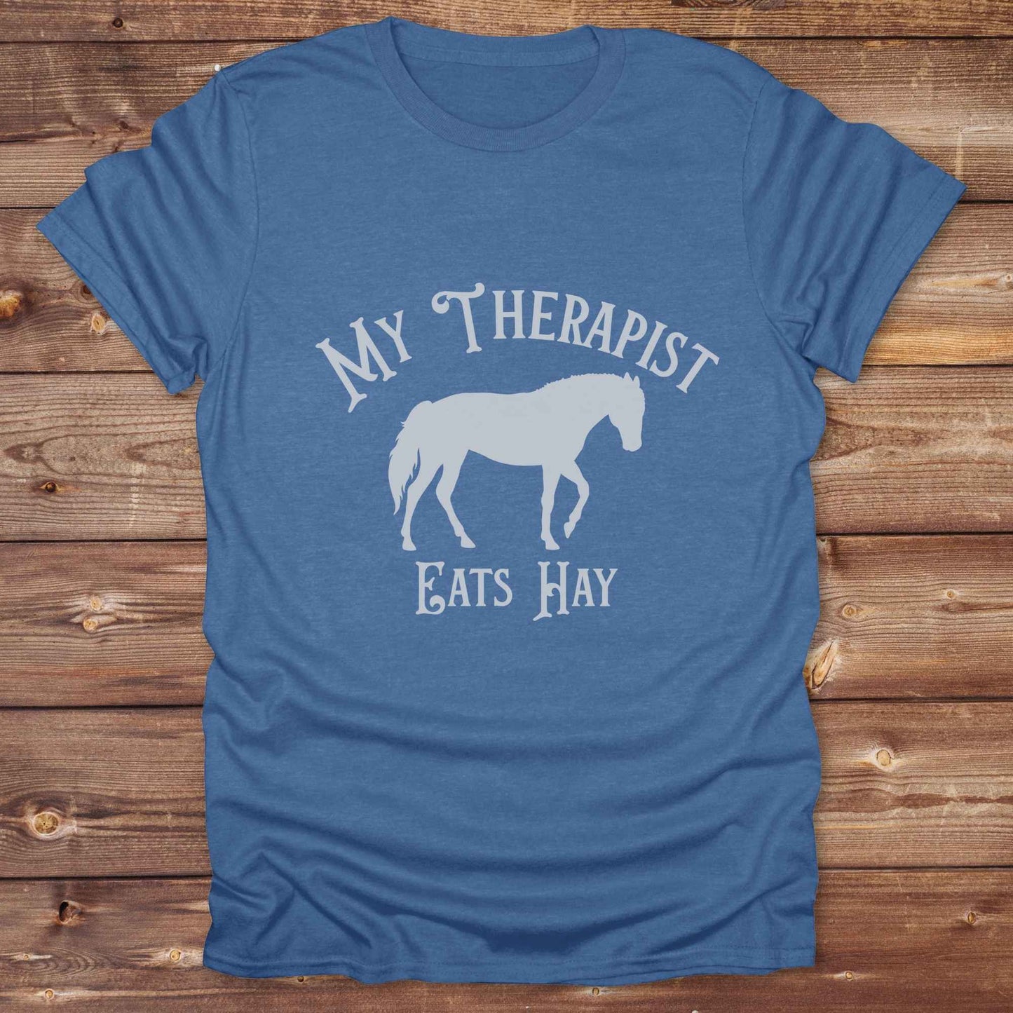 “My Therapist Eats Hay” t-shirt is the perfect mix of humor and horse lover pride, made for cowgirls, cowboys, and western enthusiasts alike. Featuring a bold horse silhouette and vintage western font, it’s ideal for barn days, rodeo nights, or gifting to someone who finds peace in the pasture. Great for birthdays, country events, or just repping your equine therapist with style. Whether you ride for fun or sanity, this western tee keeps the cowboy spirit alive with every wear.