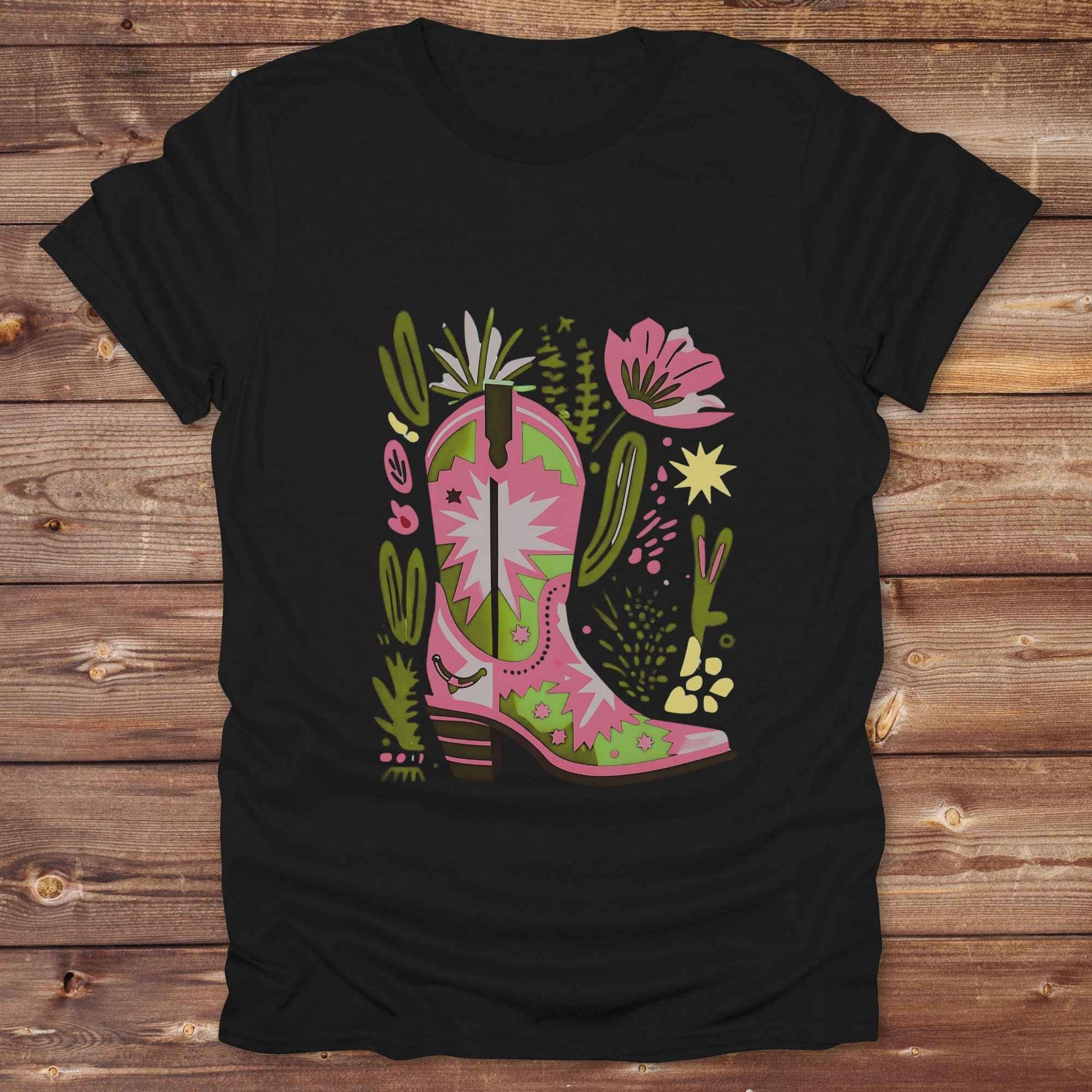 Bright pink and green cowgirl boot printed on a unisex western t-shirt, styled for a boho country vibe. The design is surrounded by floral and cactus illustrations to enhance the desert western theme.