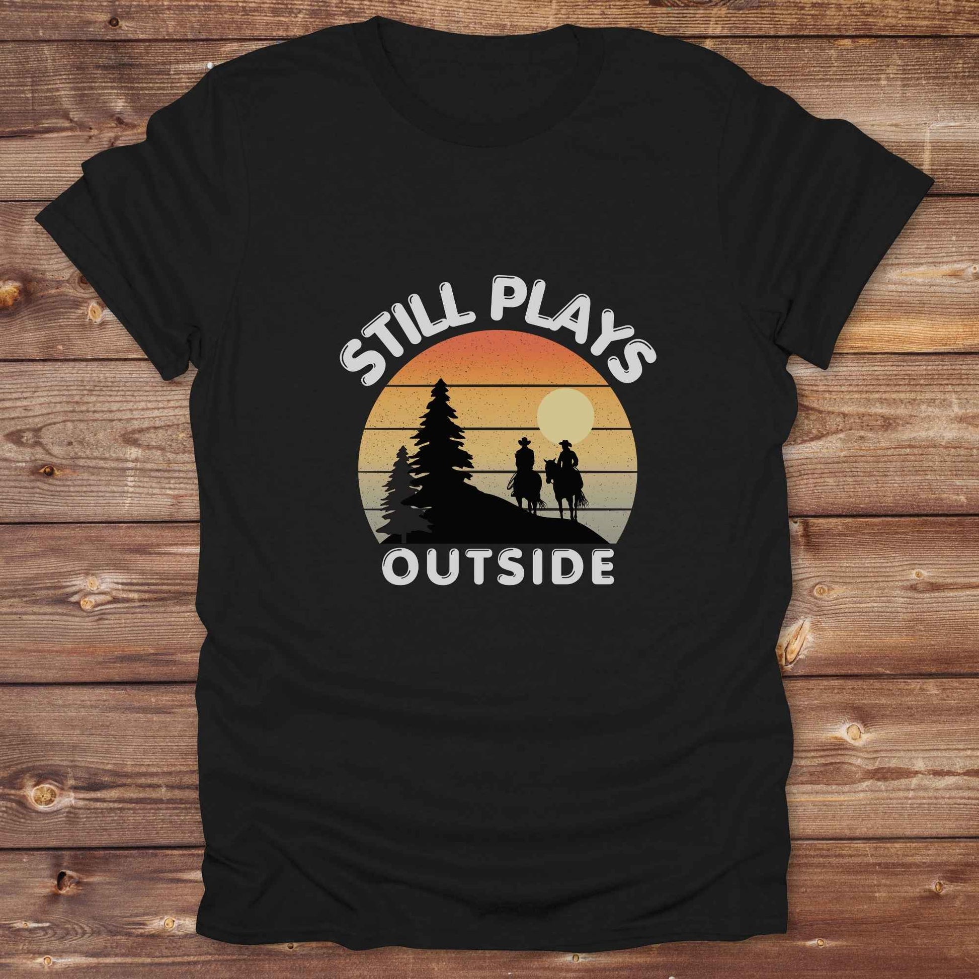 Still plays outside. Funny western t-shirt featuring horse-themed design for cowgirls, cowboys, and equestrians — perfect for rodeo lovers, rustic style fans, and horse people. Unique graphic tee by Lasso and Loom.