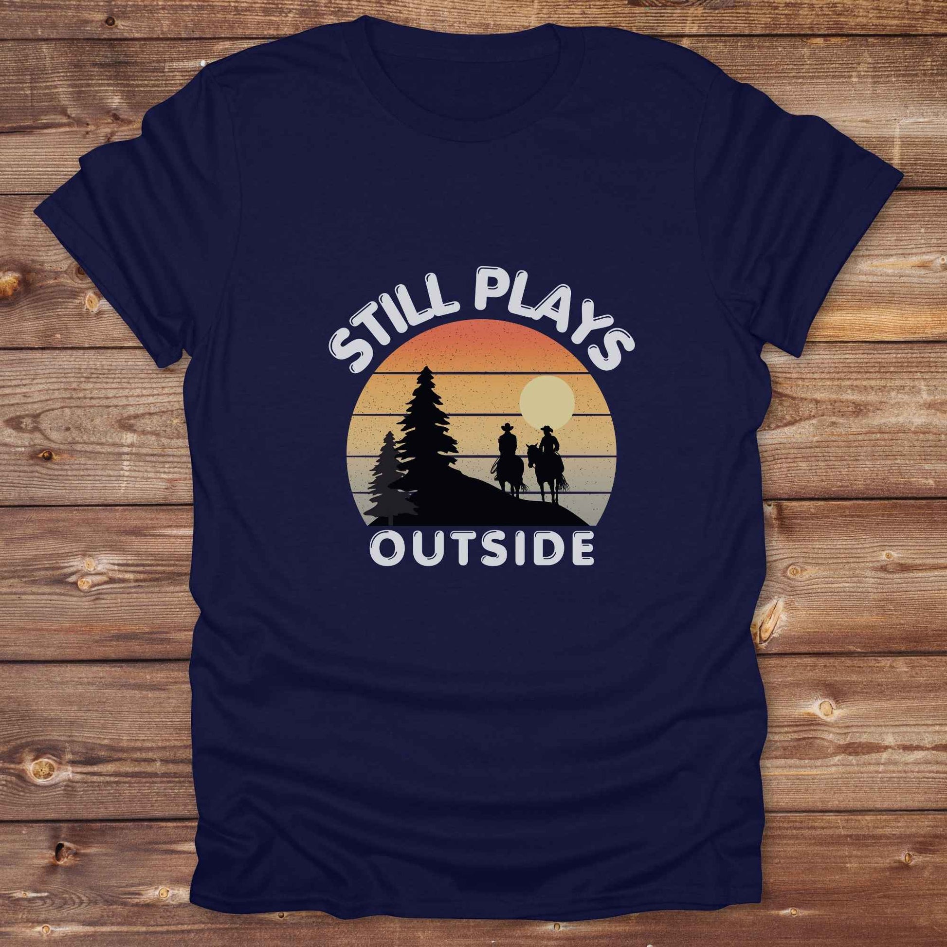 Still plays outside. Funny western t-shirt featuring horse-themed design for cowgirls, cowboys, and equestrians — perfect for rodeo lovers, rustic style fans, and horse people. Unique graphic tee by Lasso and Loom.