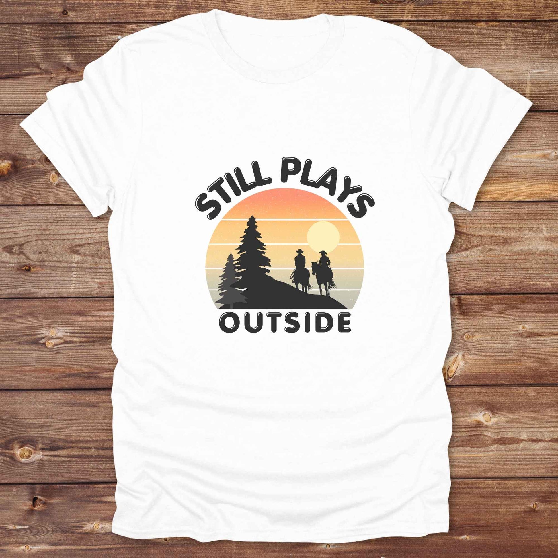 Still plays outside. Funny western t-shirt featuring horse themed design for cowgirls, cowboys, and equestrians — perfect for rodeo lovers, rustic style fans, and horse people. Unique graphic tee by Lasso and Loom.