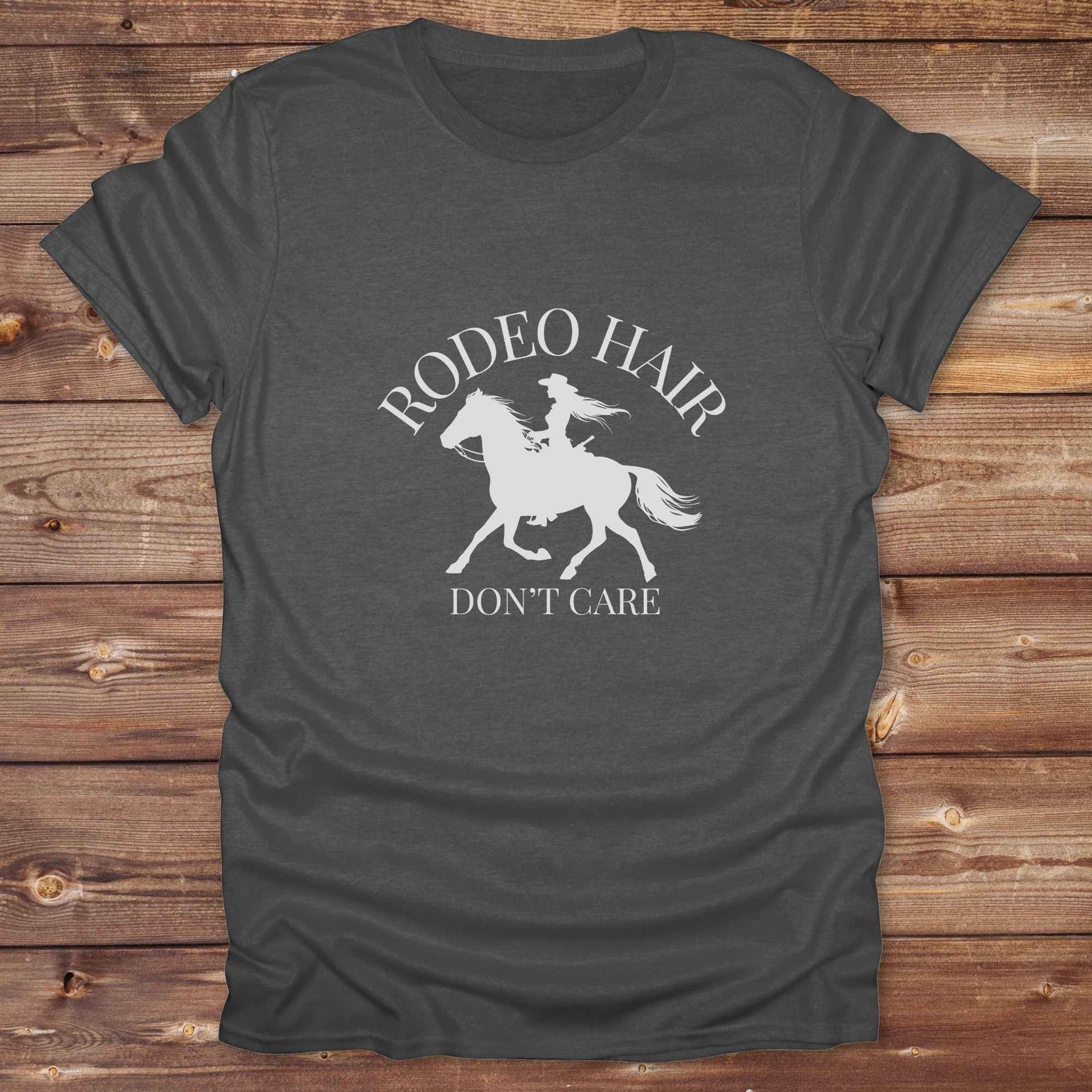 ypography cowgirl t-shirt styled for rodeo lovers and horse girls on rustic wooden background. Trendy cowgirl shirt designed for horse lovers, featuring bold western lettering in graphic style. Horse riding themed t-shirt with country slogan “Rodeo Hair Don’t Care” styled for modern cowgirls.