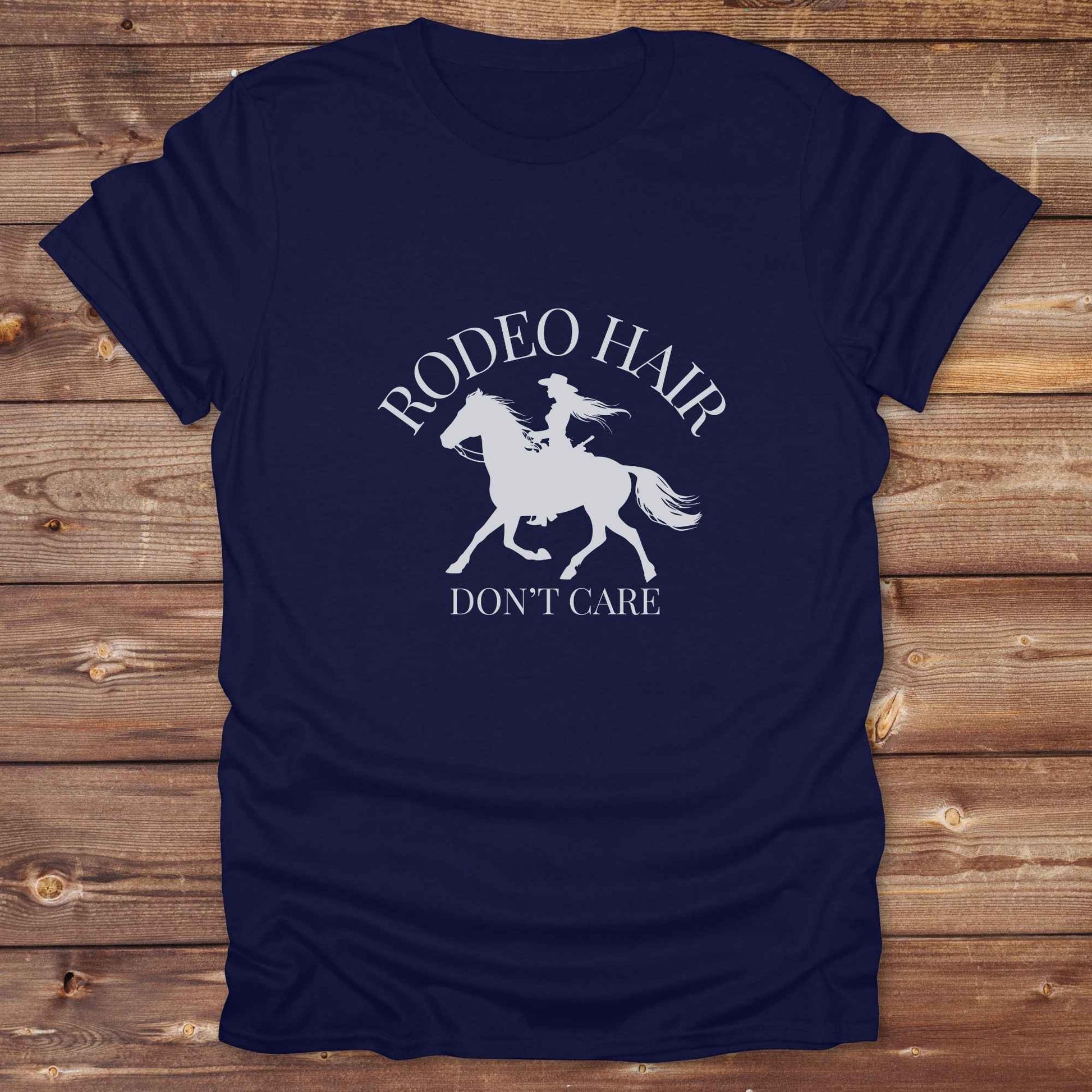 ypography cowgirl t-shirt styled for rodeo lovers and horse girls on rustic wooden background. Trendy cowgirl shirt designed for horse lovers, featuring bold western lettering in graphic style. Horse riding themed t-shirt with country slogan “Rodeo Hair Don’t Care” styled for modern cowgirls.