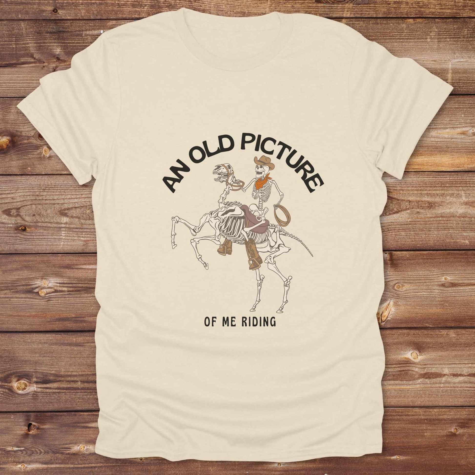 Saddle up with spooky western vibes in this skeleton cowboy “Old Picture of Me Riding” shirt, perfect for rodeo lovers and Halloween humor fans. This cowboy skeleton t-shirt combines retro western style with dark humor, ideal for ranchers, riders, and funny costume alternatives. Make fall fashion unforgettable with this witty, rustic western parody tee featuring bones, boots, and bold cowboy nostalgia.