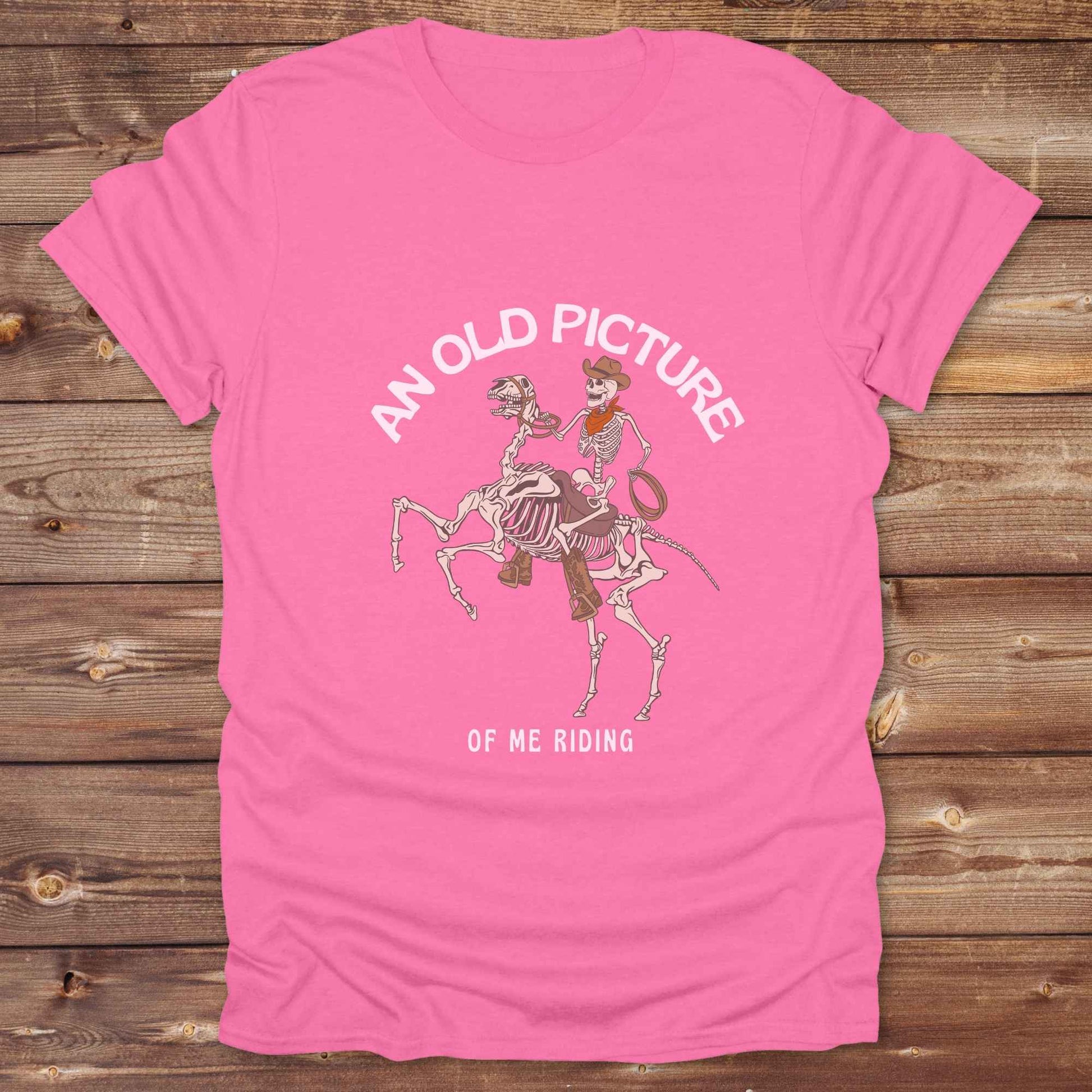 Saddle up with spooky western vibes in this skeleton cowboy “Old Picture of Me Riding” shirt, perfect for rodeo lovers and Halloween humor fans. This cowboy skeleton t-shirt combines retro western style with dark humor, ideal for ranchers, riders, and funny costume alternatives. Make fall fashion unforgettable with this witty, rustic western parody tee featuring bones, boots, and bold cowboy nostalgia.