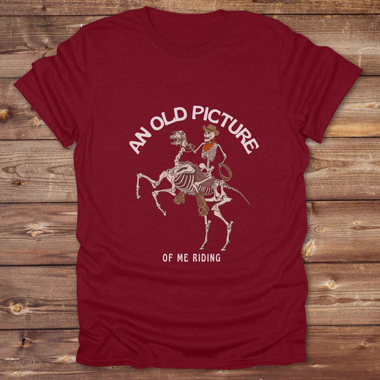 Saddle up with spooky western vibes in this skeleton cowboy “Old Picture of Me Riding” shirt, perfect for rodeo lovers and Halloween humor fans. This cowboy skeleton t-shirt combines retro western style with dark humor, ideal for ranchers, riders, and funny costume alternatives. Make fall fashion unforgettable with this witty, rustic western parody tee featuring bones, boots, and bold cowboy nostalgia.