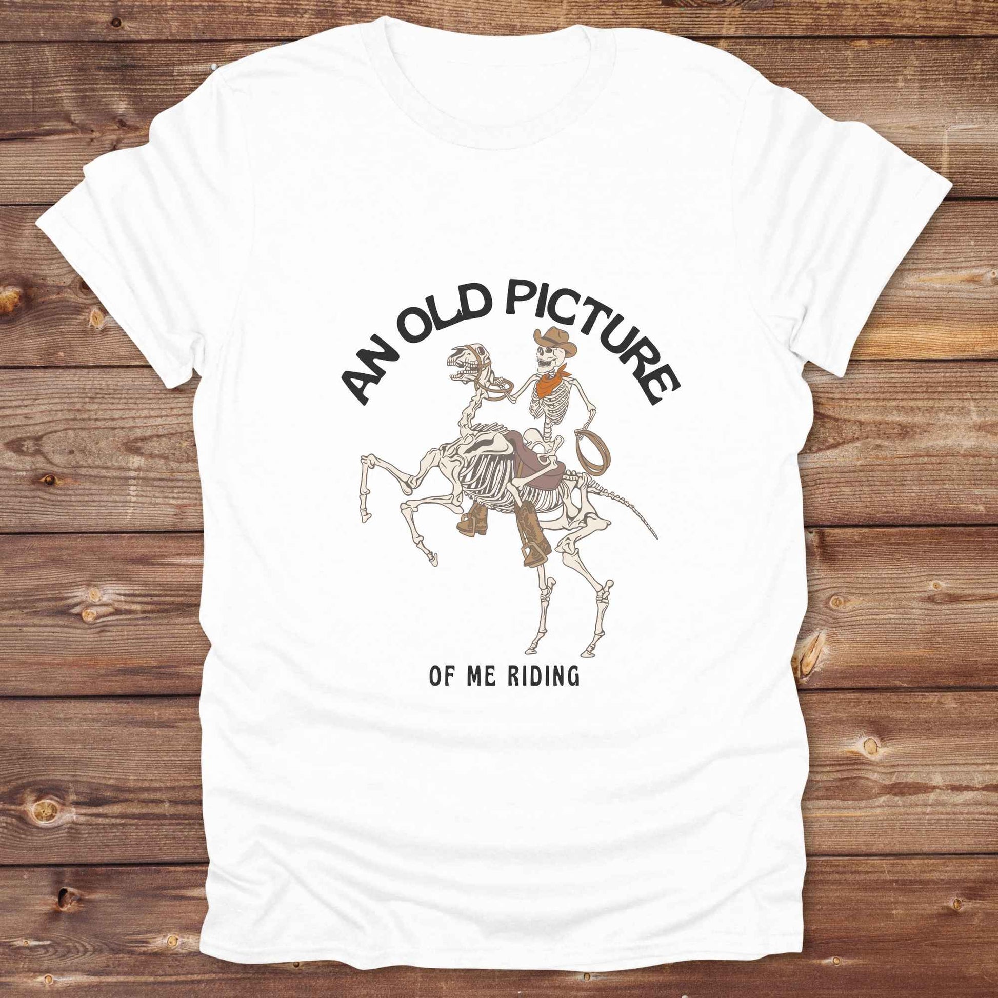 Saddle up with spooky western vibes in this skeleton cowboy “Old Picture of Me Riding” shirt, perfect for rodeo lovers and Halloween humor fans. This cowboy skeleton t-shirt combines retro western style with dark humor, ideal for ranchers, riders, and funny costume alternatives. Make fall fashion unforgettable with this witty, rustic western parody tee featuring bones, boots, and bold cowboy nostalgia.