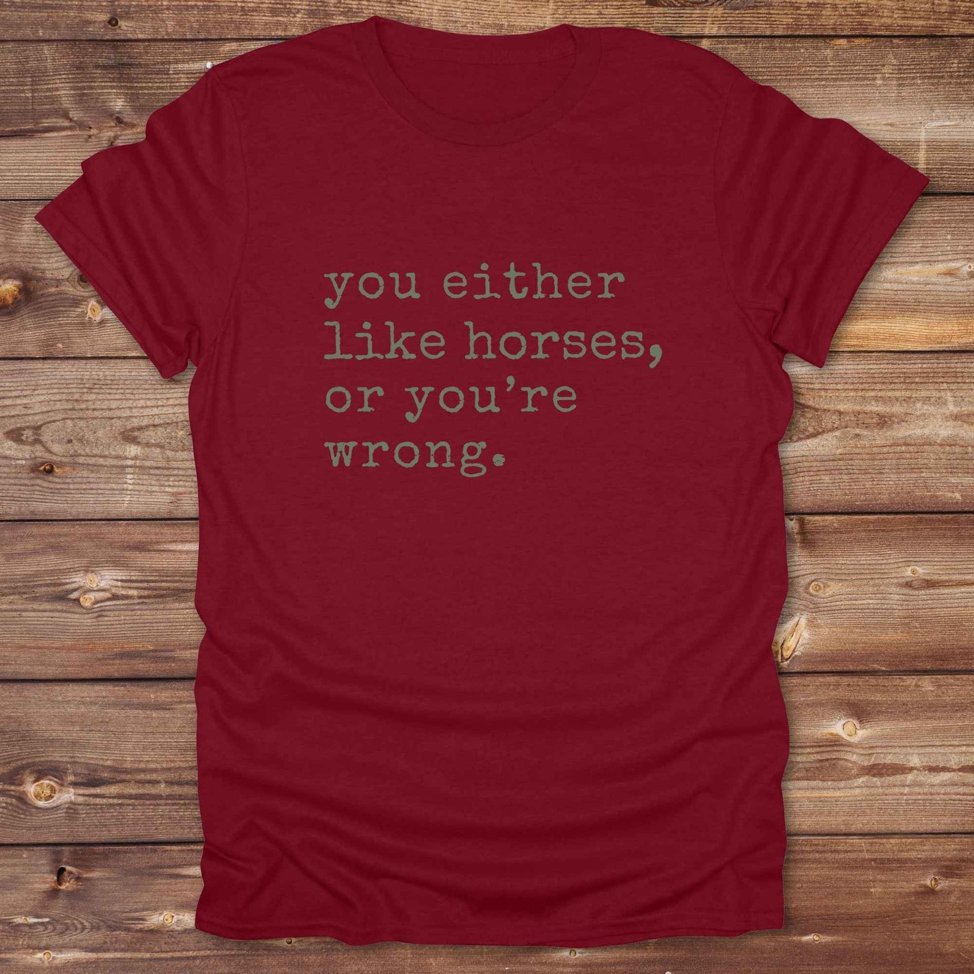 Red t-shirt with text 'you either like horses, or you're wrong' on a wooden surface. Show your love for horses loud and proud with this funny typography western tee ,perfect for cowgirls, ranchers, and equestrians. 
This “You either like horses or you're wrong” t-shirt is a hilarious must have for horse lovers with sass and sarcasm. Ideal gift for any horse girl or cowboy, this rustic western Gildan tee blends humor with horse life perfectly. Whether you’re mucking stalls or riding trails, this sarcastic ho
