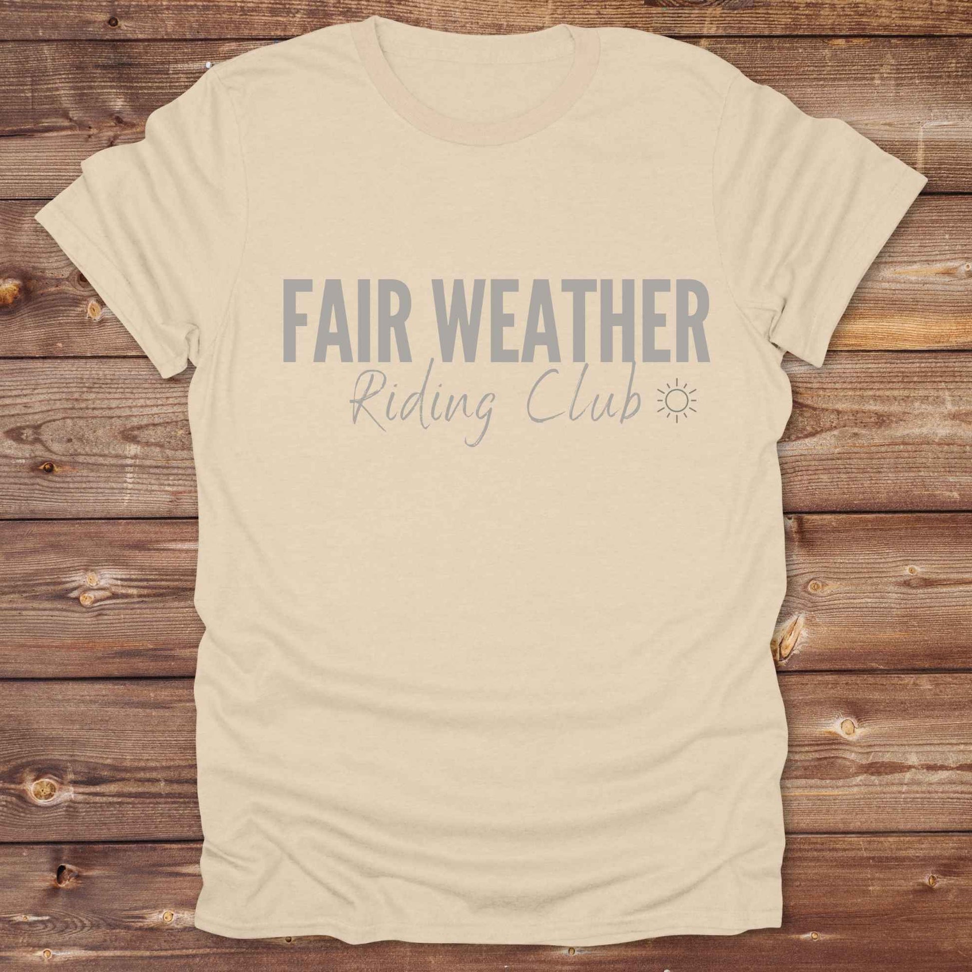 "Fair Weather Riding Club” tee brings western charm and playful equestrian humor together in a bold design that speaks to cowboys and cowgirls alike. erfect for horse lovers who only ride in sunshine. Featuring clean typography and a cute sun icon, it’s the ultimate cowboy core essential for rodeo days, trail rides, or just lounging in the barn. Whether it’s for yourself or as a gift for a fellow rider, this western quote tee adds a sunny twist to any rustic outfit. must have for any modern day trailblazer.