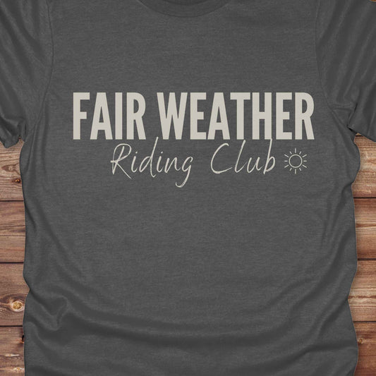 "Fair Weather Riding Club” tee brings western charm and playful equestrian humor together in a bold design that speaks to cowboys and cowgirls alike. erfect for horse lovers who only ride in sunshine. Featuring clean typography and a cute sun icon, it’s the ultimate cowboy core essential for rodeo days, trail rides, or just lounging in the barn. Whether it’s for yourself or as a gift for a fellow rider, this western quote tee adds a sunny twist to any rustic outfit. must have for any modern day trailblazer.