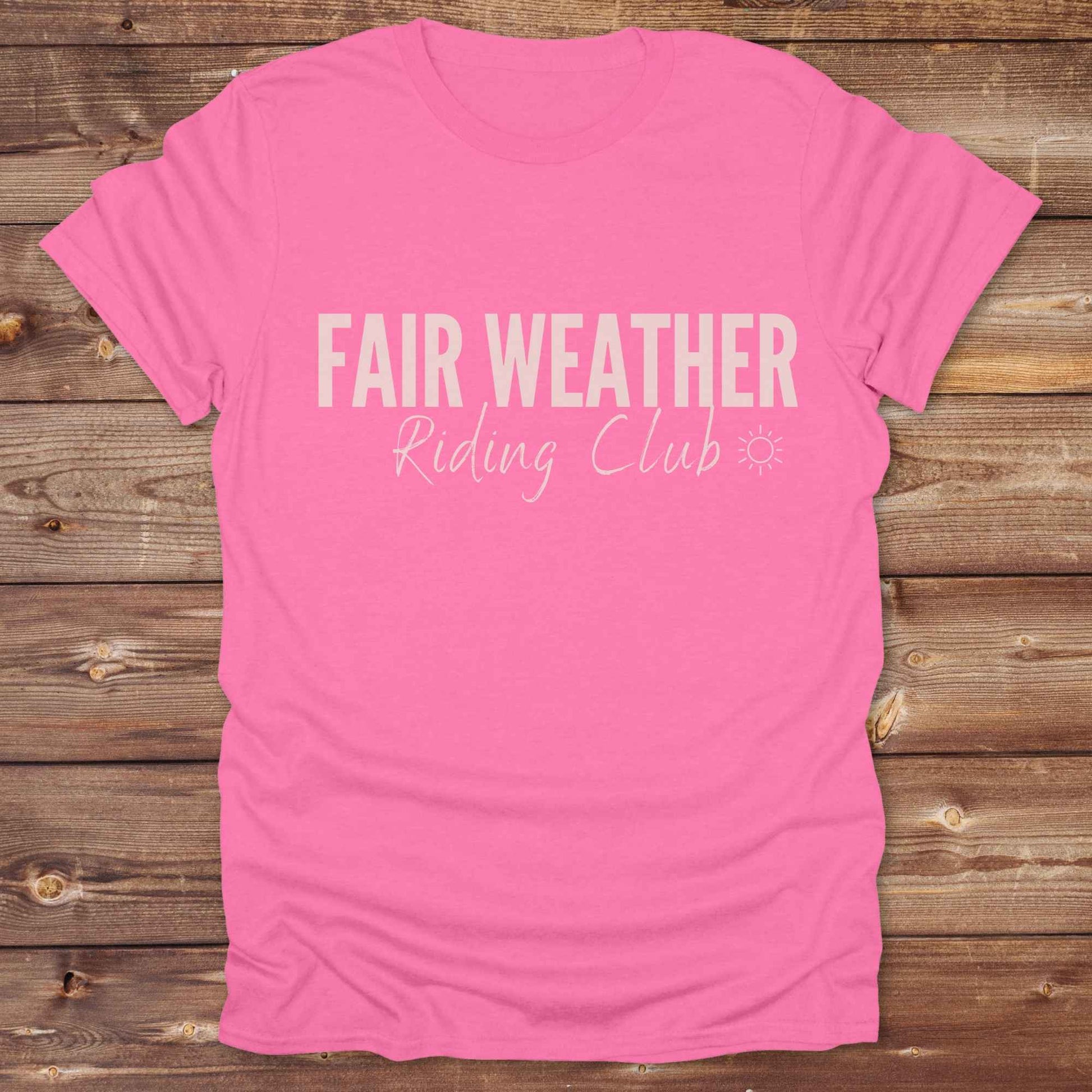 "Fair Weather Riding Club” tee brings western charm and playful equestrian humor together in a bold design that speaks to cowboys and cowgirls alike. erfect for horse lovers who only ride in sunshine. Featuring clean typography and a cute sun icon, it’s the ultimate cowboy core essential for rodeo days, trail rides, or just lounging in the barn. Whether it’s for yourself or as a gift for a fellow rider, this western quote tee adds a sunny twist to any rustic outfit. must have for any modern day trailblazer.