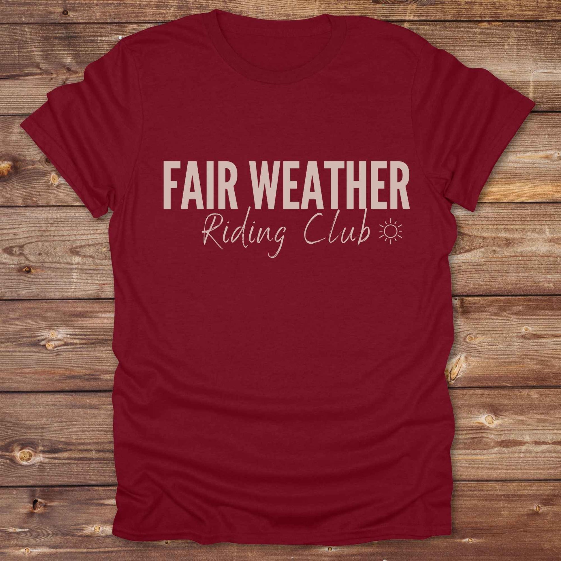 "Fair Weather Riding Club” tee brings western charm and playful equestrian humor together in a bold design that speaks to cowboys and cowgirls alike. erfect for horse lovers who only ride in sunshine. Featuring clean typography and a cute sun icon, it’s the ultimate cowboy core essential for rodeo days, trail rides, or just lounging in the barn. Whether it’s for yourself or as a gift for a fellow rider, this western quote tee adds a sunny twist to any rustic outfit. must have for any modern day trailblazer.