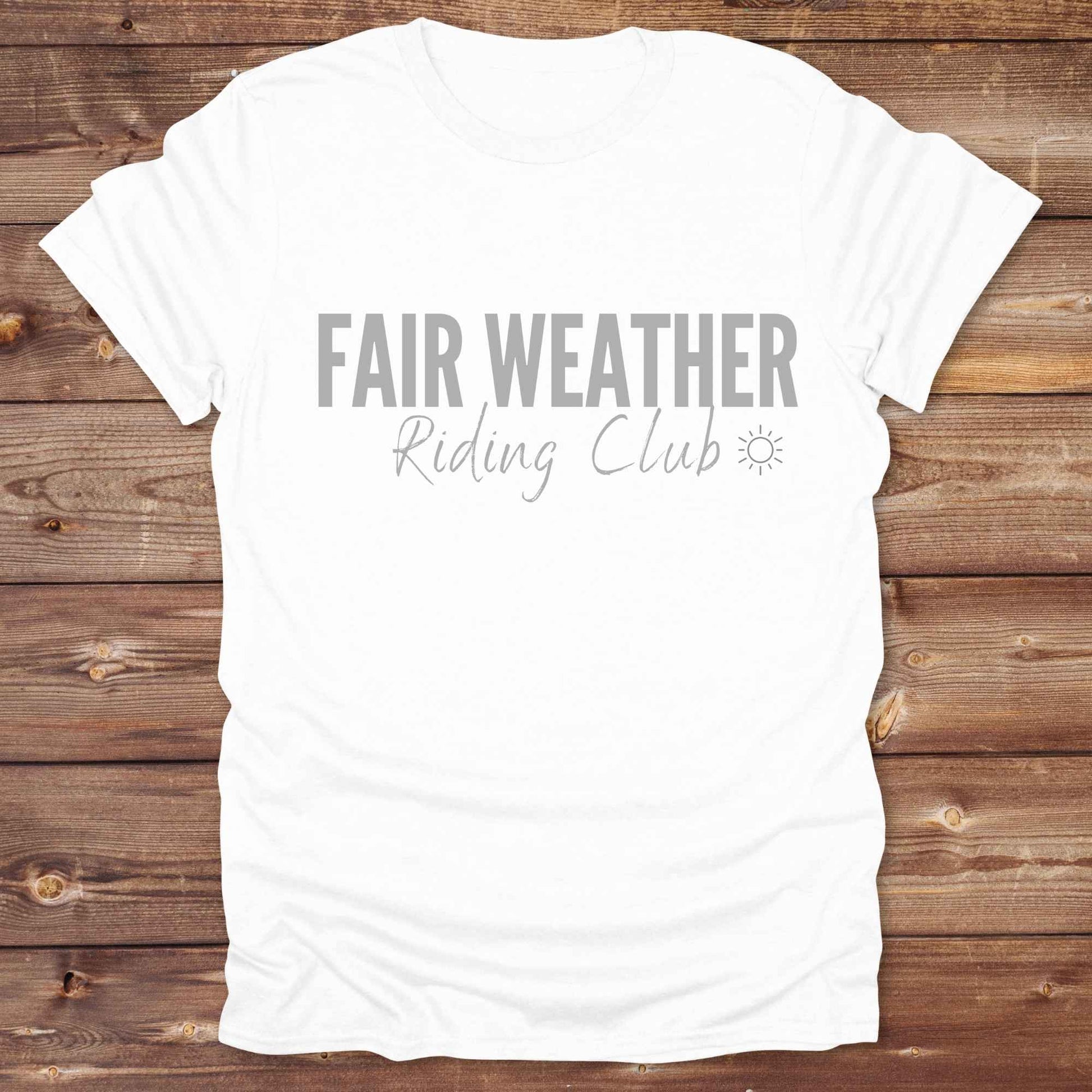 "Fair Weather Riding Club” tee brings western charm and playful equestrian humor together in a bold design that speaks to cowboys and cowgirls alike. erfect for horse lovers who only ride in sunshine. Featuring clean typography and a cute sun icon, it’s the ultimate cowboy core essential for rodeo days, trail rides, or just lounging in the barn. Whether it’s for yourself or as a gift for a fellow rider, this western quote tee adds a sunny twist to any rustic outfit. must have for any modern day trailblazer.