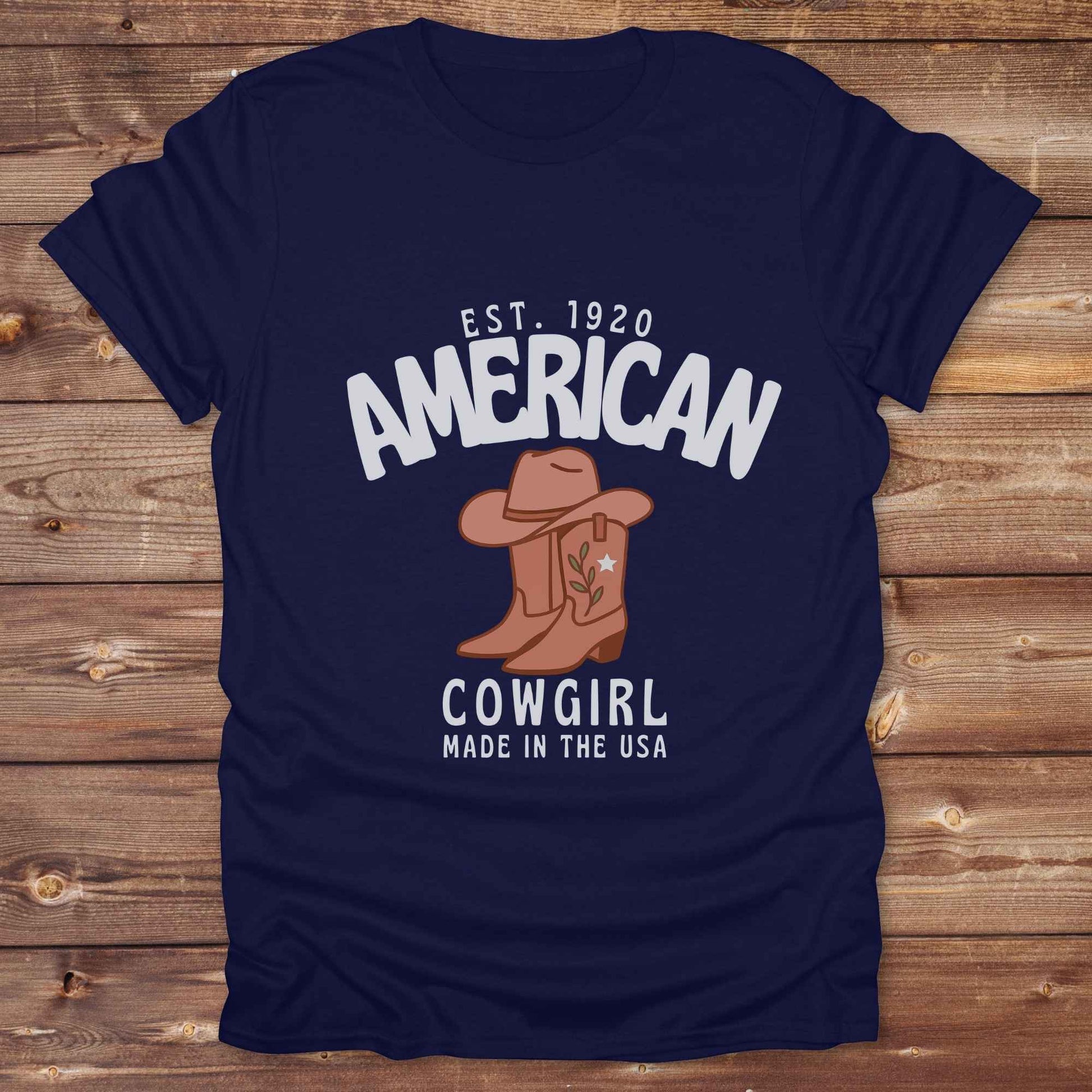 This American Cowgirl T-Shirt is the perfect mix of bold western pride and boho rodeo style. Featuring a rustic boot and hat graphic, it's made for country girls who live for rodeo season and horse rides. It’s a statement piece for cowgirls, country lovers, and western fashion fans alike. Whether you’re gifting it for a birthday or styling it for your next state fair, this tee brings serious cowboy core energy to your closet.  A must have for horse lovers.