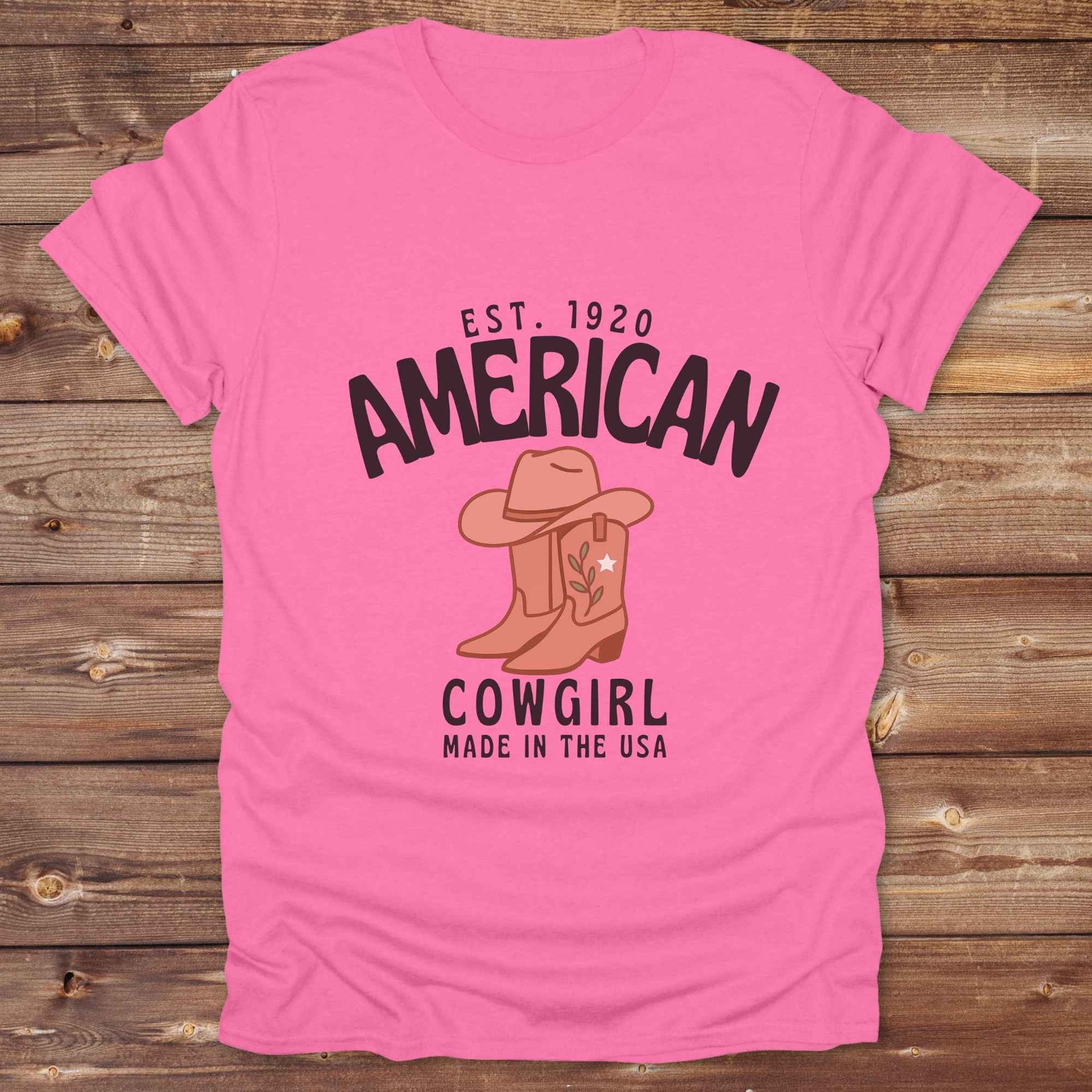 This American Cowgirl T-Shirt is the perfect mix of bold western pride and boho rodeo style. Featuring a rustic boot and hat graphic, it's made for country girls who live for rodeo season and horse rides. It’s a statement piece for cowgirls, country lovers, and western fashion fans alike. Whether you’re gifting it for a birthday or styling it for your next state fair, this tee brings serious cowboy core energy to your closet.  A must have for horse lovers.