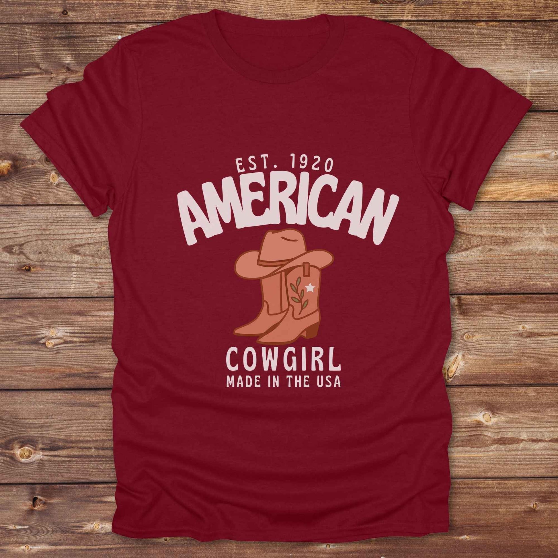 This American Cowgirl T-Shirt is the perfect mix of bold western pride and boho rodeo style. Featuring a rustic boot and hat graphic, it's made for country girls who live for rodeo season and horse rides. It’s a statement piece for cowgirls, country lovers, and western fashion fans alike. Whether you’re gifting it for a birthday or styling it for your next state fair, this tee brings serious cowboy core energy to your closet.  A must have for horse lovers.