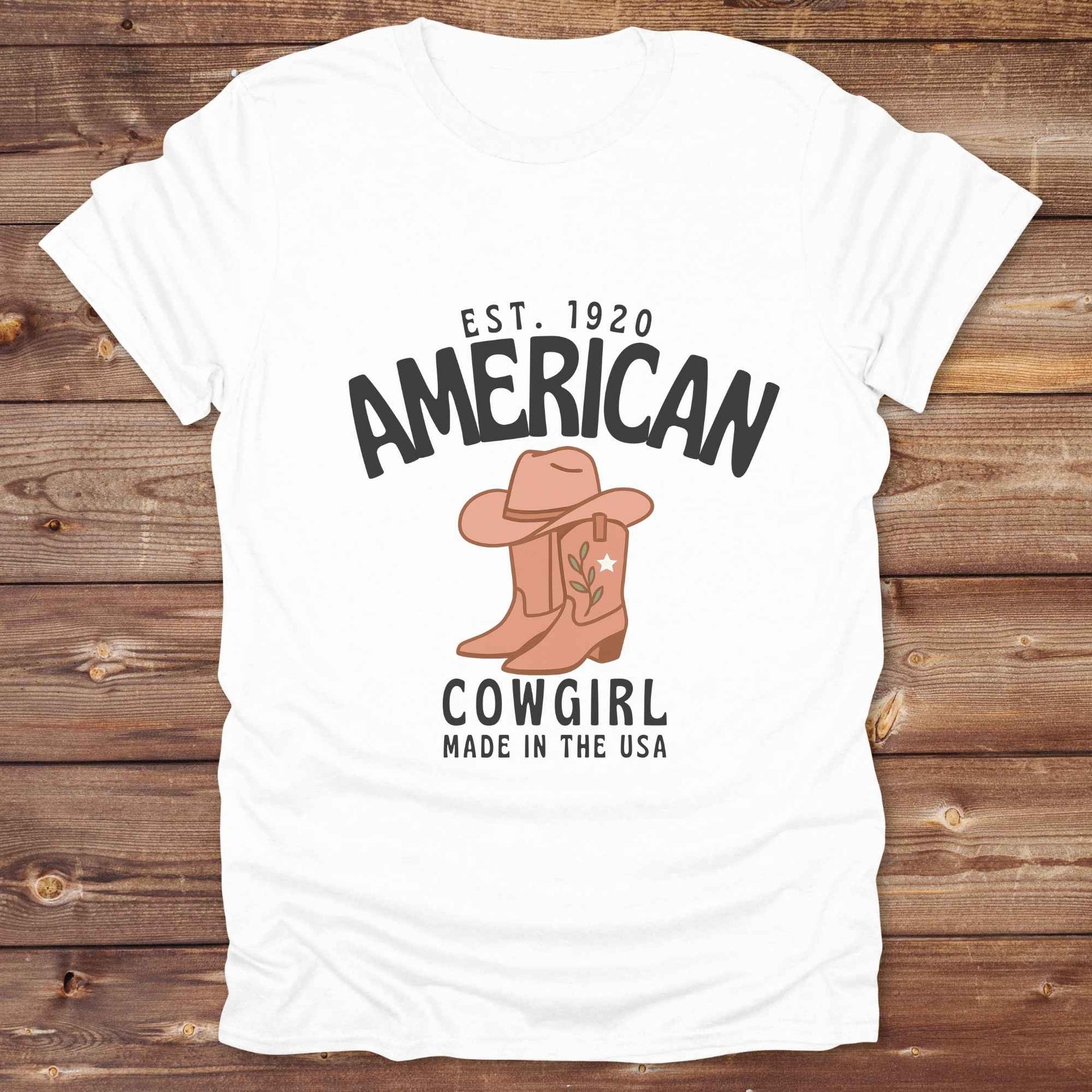 This American Cowgirl T-Shirt is the perfect mix of bold western pride and boho rodeo style. Featuring a rustic boot and hat graphic, it's made for country girls who live for rodeo season and horse rides. It’s a statement piece for cowgirls, country lovers, and western fashion fans alike. Whether you’re gifting it for a birthday or styling it for your next state fair, this tee brings serious cowboy core energy to your closet.  A must have for horse lovers.