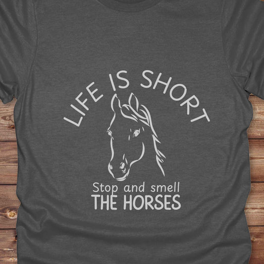 Life is short stop and smell the horses tee. perfect for rodeo fans, horse moms, country girls, and anyone who embraces equestrian life. Whether you're mucking stalls, trail riding, or hitting the local country fair, this rustic shirt makes a fun and relatable statement. It’s the ideal gift for birthdays, holidays, or spontaneous barn day laughs.