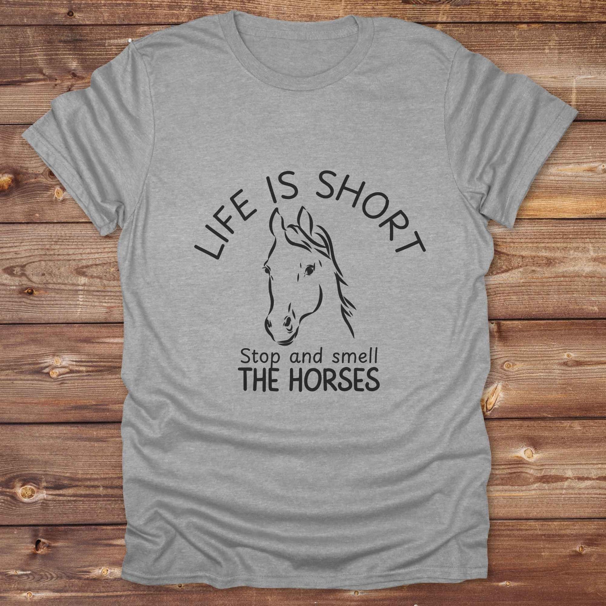 Life is short stop and smell the horses tee. perfect for rodeo fans, horse moms, country girls, and anyone who embraces equestrian life. Whether you're mucking stalls, trail riding, or hitting the local country fair, this rustic shirt makes a fun and relatable statement. It’s the ideal gift for birthdays, holidays, or spontaneous barn day laughs.