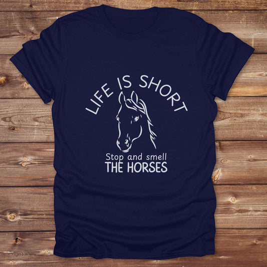 Life is short stop and smell the horses tee. perfect for rodeo fans, horse moms, country girls, and anyone who embraces equestrian life. Whether you're mucking stalls, trail riding, or hitting the local country fair, this rustic shirt makes a fun and relatable statement. It’s the ideal gift for birthdays, holidays, or spontaneous barn day laughs.