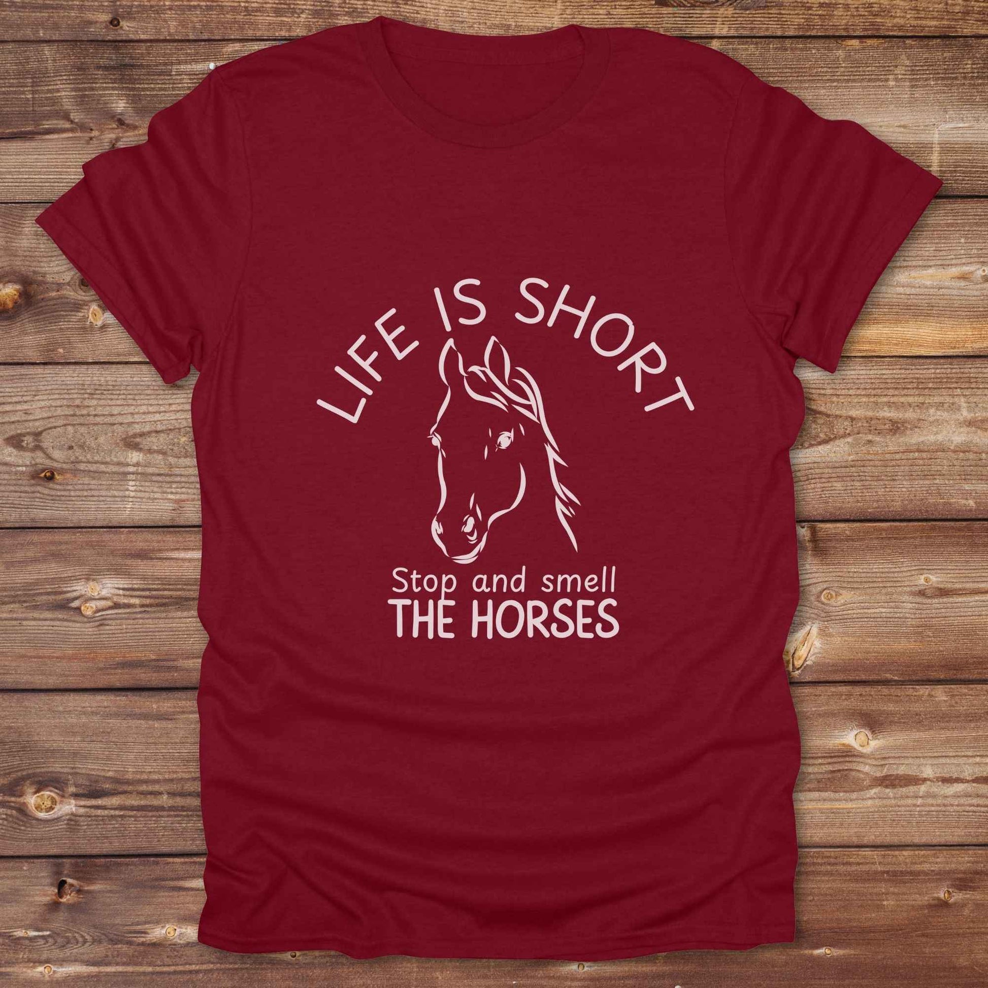 Life is short stop and smell the horses tee. perfect for rodeo fans, horse moms, country girls, and anyone who embraces equestrian life. Whether you're mucking stalls, trail riding, or hitting the local country fair, this rustic shirt makes a fun and relatable statement. It’s the ideal gift for birthdays, holidays, or spontaneous barn day laughs.