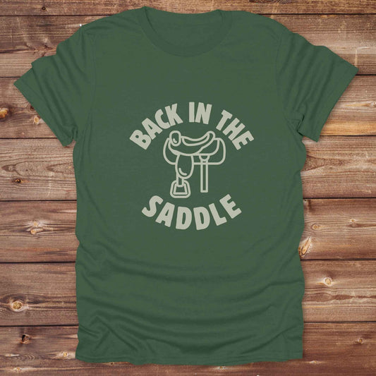 Our "Back in the Saddle" t-shirt is the perfect western-style graphic tee for cowboys and cowgirls who love horseback riding, rodeo culture, and rustic country fashion. Featuring a clean saddle illustration and retro western typography, this shirt blends comfort and character, making it ideal for ranch wear, horse lovers, and rodeo enthusiasts. Whether you're heading to a country concert, festival, or barn, this tee stands out. Makes a great gift for horse riders, western fans or anyone getting back riding