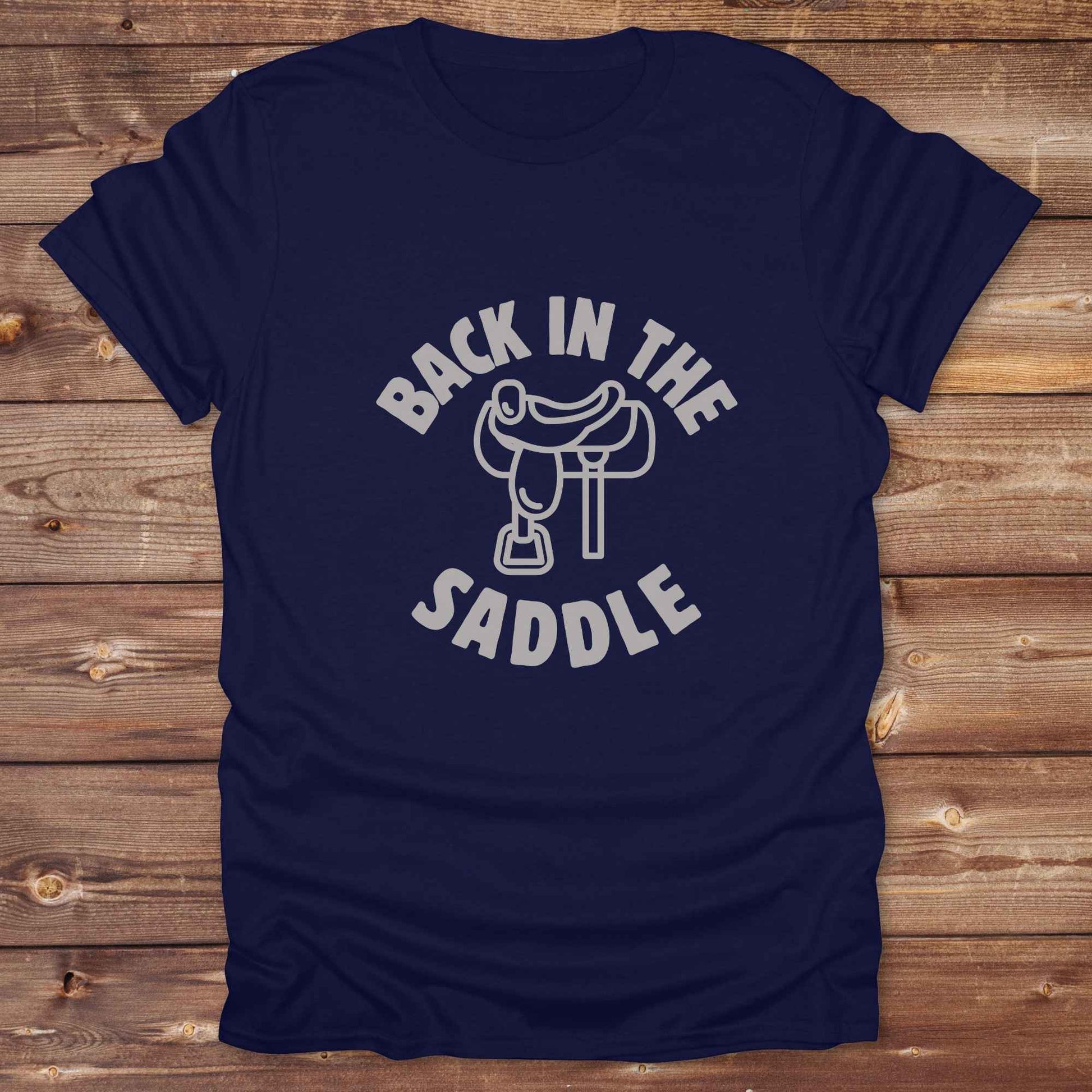Our "Back in the Saddle" t-shirt is the perfect western-style graphic tee for cowboys and cowgirls who love horseback riding, rodeo culture, and rustic country fashion. Featuring a clean saddle illustration and retro western typography, this shirt blends comfort and character, making it ideal for ranch wear, horse lovers, and rodeo enthusiasts. Whether you're heading to a country concert, festival, or barn, this tee stands out. Makes a great gift for horse riders, western fans or anyone getting back riding