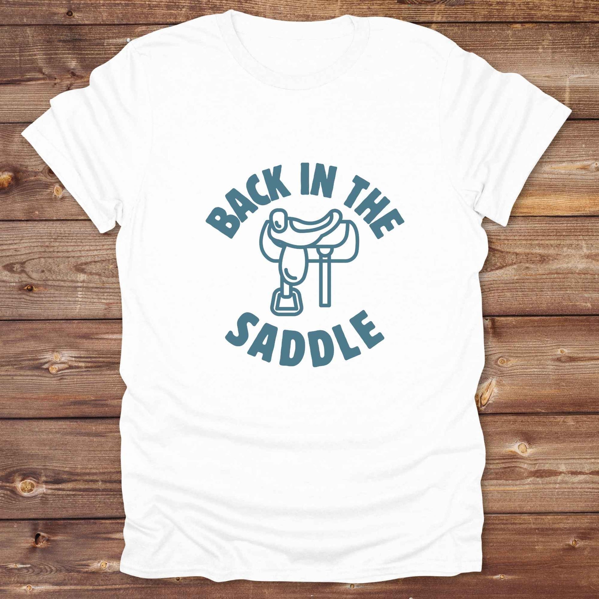 Our "Back in the Saddle" t-shirt is the perfect western-style graphic tee for cowboys and cowgirls who love horseback riding, rodeo culture, and rustic country fashion. Featuring a clean saddle illustration and retro western typography, this shirt blends comfort and character, making it ideal for ranch wear, horse lovers, and rodeo enthusiasts. Whether you're heading to a country concert, festival, or barn, this tee stands out. Makes a great gift for horse riders, western fans or anyone getting back riding