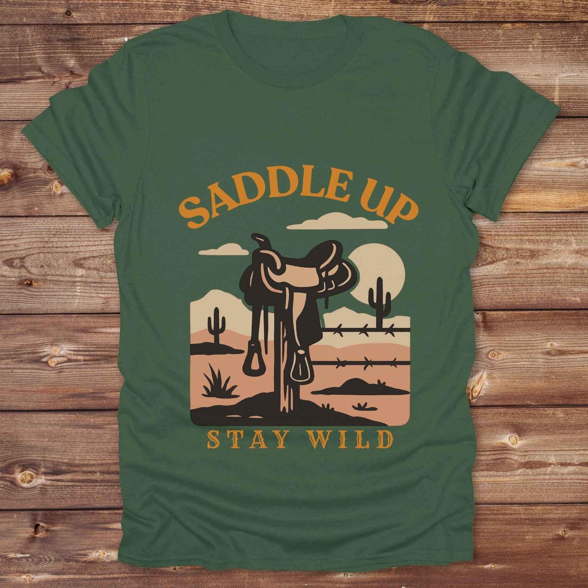 Saddle Up Stay Wild western t-shirt features a bold desert sunset graphic with a classic saddle and western landscape. Perfect for cowgirls, cowboys, and horse lovers, this rustic tee blends adventure with comfort and country charm. Whether you're heading to a rodeo, trail ride, or simply embracing your wild side, this shirt offers a soft fit and bold design. Designed for western wear fans, equestrians, and country souls, it's a must have for anyone who lives the saddle life.