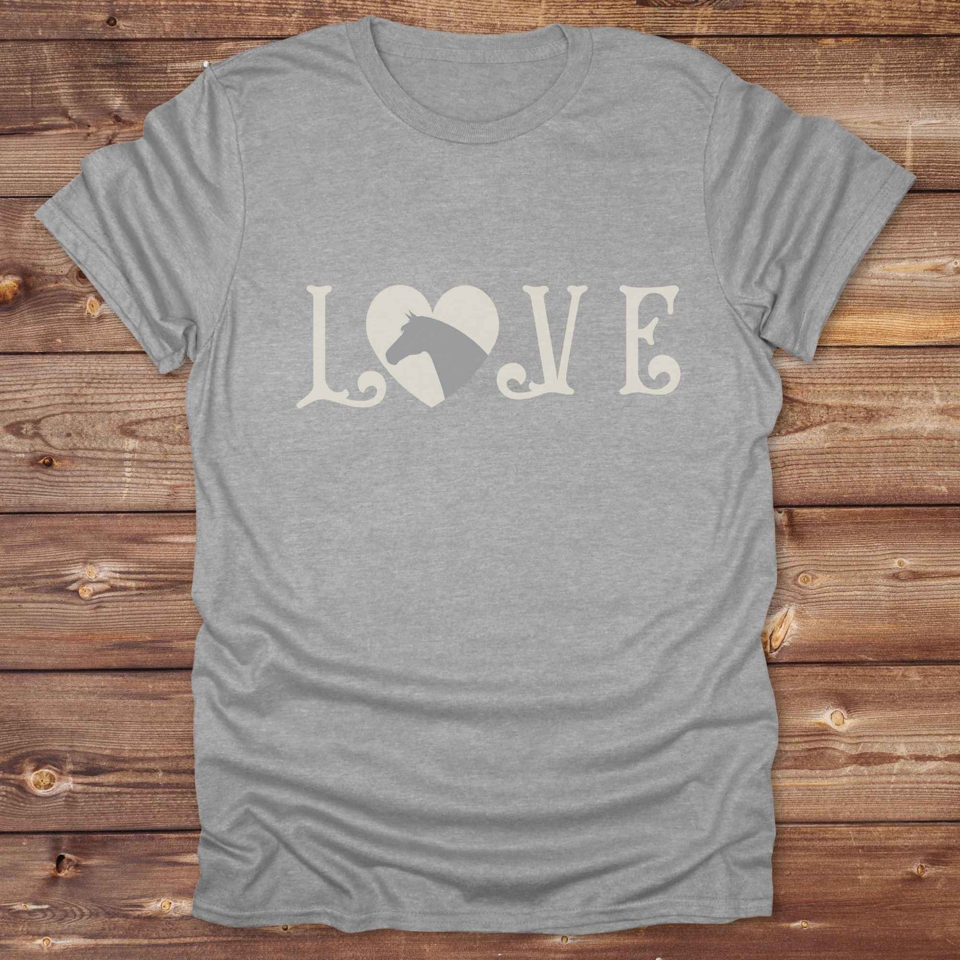 This Love Horses T-Shirt is the perfect expression of passion for horse lovers and cowgirls alike. With a unique heart-and-horse silhouette design and rustic western typography, it makes a thoughtful gift for birthdays, rodeo lovers, equestrians, and country women who live the cowboy lifestyle. The tee pairs well with denim, boots, and a bold cowgirl spirit. Whether for barn days, trail rides, or everyday western fashion, this shirt belongs in your rodeo ready wardrobe.
