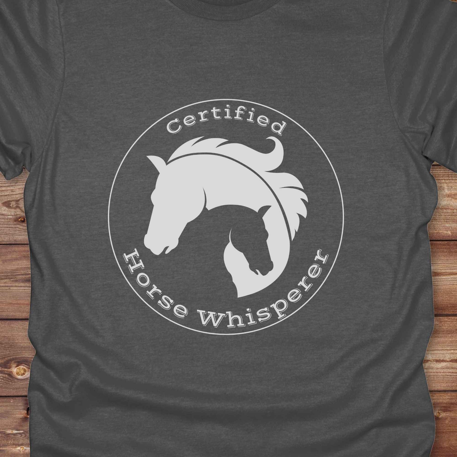 Certified Horse Whisperer T-Shirt is the perfect blend of rustic charm and equestrian elegance. Designed for horse lovers, cowboys, cowgirls, and trainers, this soft unisex graphic tee showcases a minimalist silhouette of two horses within a bold “Certified Horse Whisperer” typographic circle. It's a great gift for birthdays, rodeo fans, western riders, and anyone practicing natural horsemanship or quiet leadership. Conversation starter at the barn, rodeo, trail ride, or farmer’s market. Loved by riders.