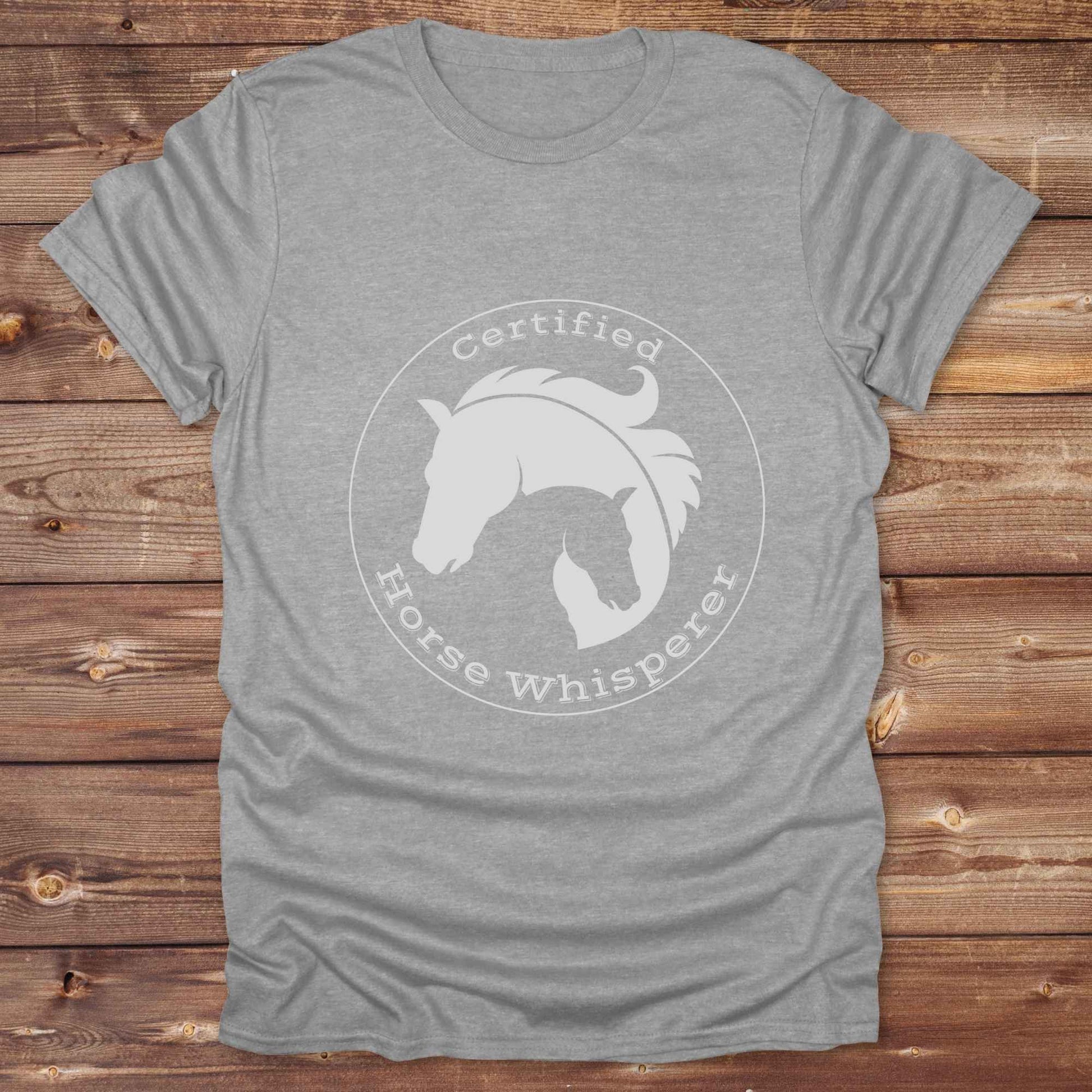 Certified Horse Whisperer T-Shirt is the perfect blend of rustic charm and equestrian elegance. Designed for horse lovers, cowboys, cowgirls, and trainers, this soft unisex graphic tee showcases a minimalist silhouette of two horses within a bold “Certified Horse Whisperer” typographic circle. It's a great gift for birthdays, rodeo fans, western riders, and anyone practicing natural horsemanship or quiet leadership. Conversation starter at the barn, rodeo, trail ride, or farmer’s market. Loved by riders.