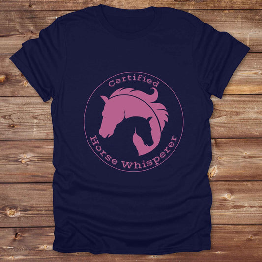 Certified Horse Whisperer T-Shirt is the perfect blend of rustic charm and equestrian elegance. Designed for horse lovers, cowboys, cowgirls, and trainers, this soft unisex graphic tee showcases a minimalist silhouette of two horses within a bold “Certified Horse Whisperer” typographic circle. It's a great gift for birthdays, rodeo fans, western riders, and anyone practicing natural horsemanship or quiet leadership. Conversation starter at the barn, rodeo, trail ride, or farmer’s market. Loved by riders.