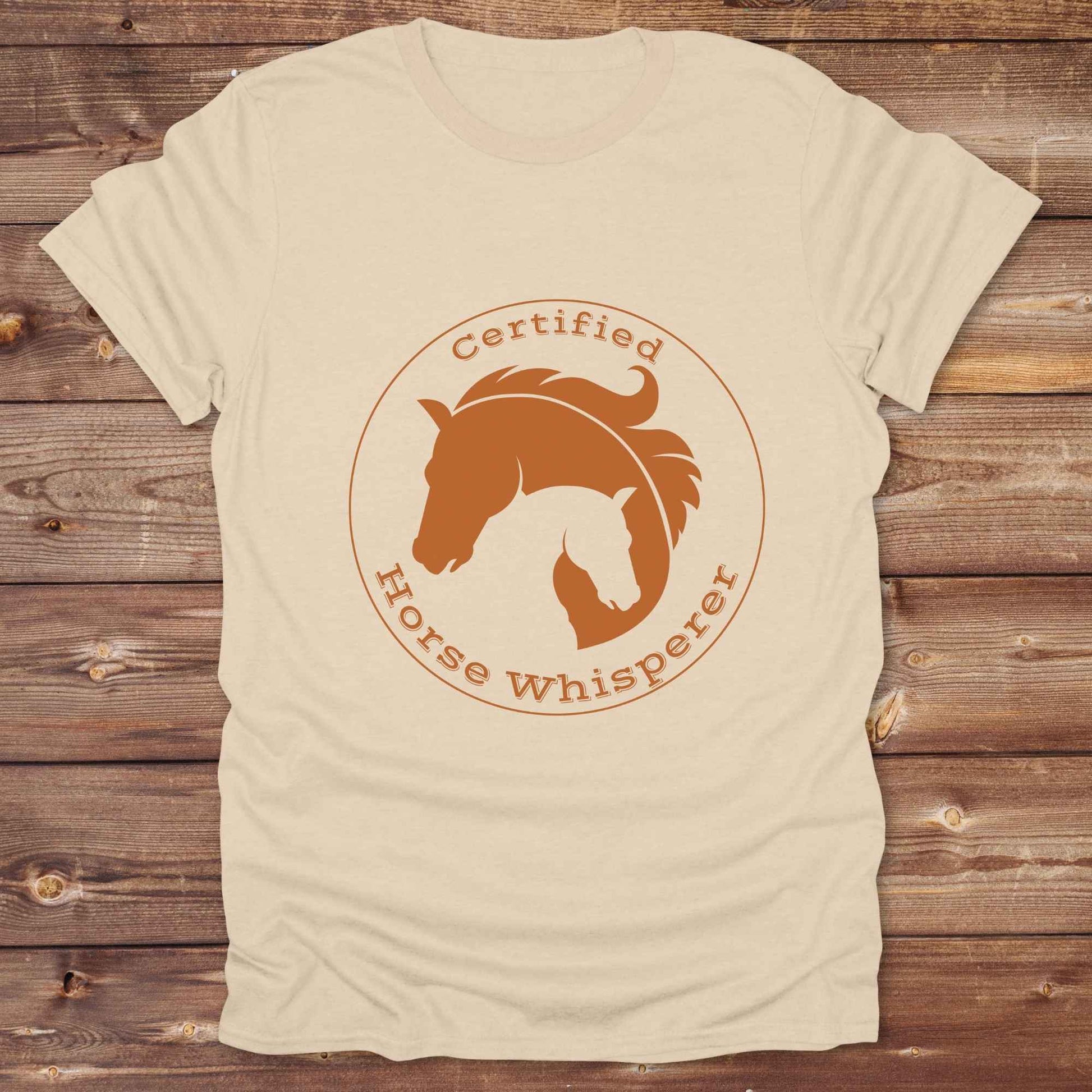 Certified Horse Whisperer T-Shirt is the perfect blend of rustic charm and equestrian elegance. Designed for horse lovers, cowboys, cowgirls, and trainers, this soft unisex graphic tee showcases a minimalist silhouette of two horses within a bold “Certified Horse Whisperer” typographic circle. It's a great gift for birthdays, rodeo fans, western riders, and anyone practicing natural horsemanship or quiet leadership. Conversation starter at the barn, rodeo, trail ride, or farmer’s market. Loved by riders.