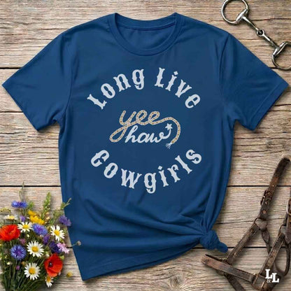 A navy blue graphic t-shirt with 'Long Live yee haw cowgirls' printed on the front, styled in a flat-lay on a rustic wooden background with flowers and horse tack.