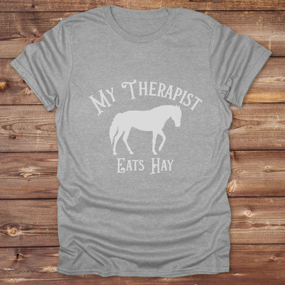 “My Therapist Eats Hay” t-shirt is the perfect mix of humor and horse lover pride, made for cowgirls, cowboys, and western enthusiasts alike. Featuring a bold horse silhouette and vintage western font, it’s ideal for barn days, rodeo nights, or gifting to someone who finds peace in the pasture. Great for birthdays, country events, or just repping your equine therapist with style. Whether you ride for fun or sanity, this western tee keeps the cowboy spirit alive with every wear.