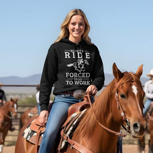 Woman riding a horse wearing a black hoodie with text and graphics. Born to Ride Hoodie for Horse Lovers, Equestrian Apparel, Barn Wear