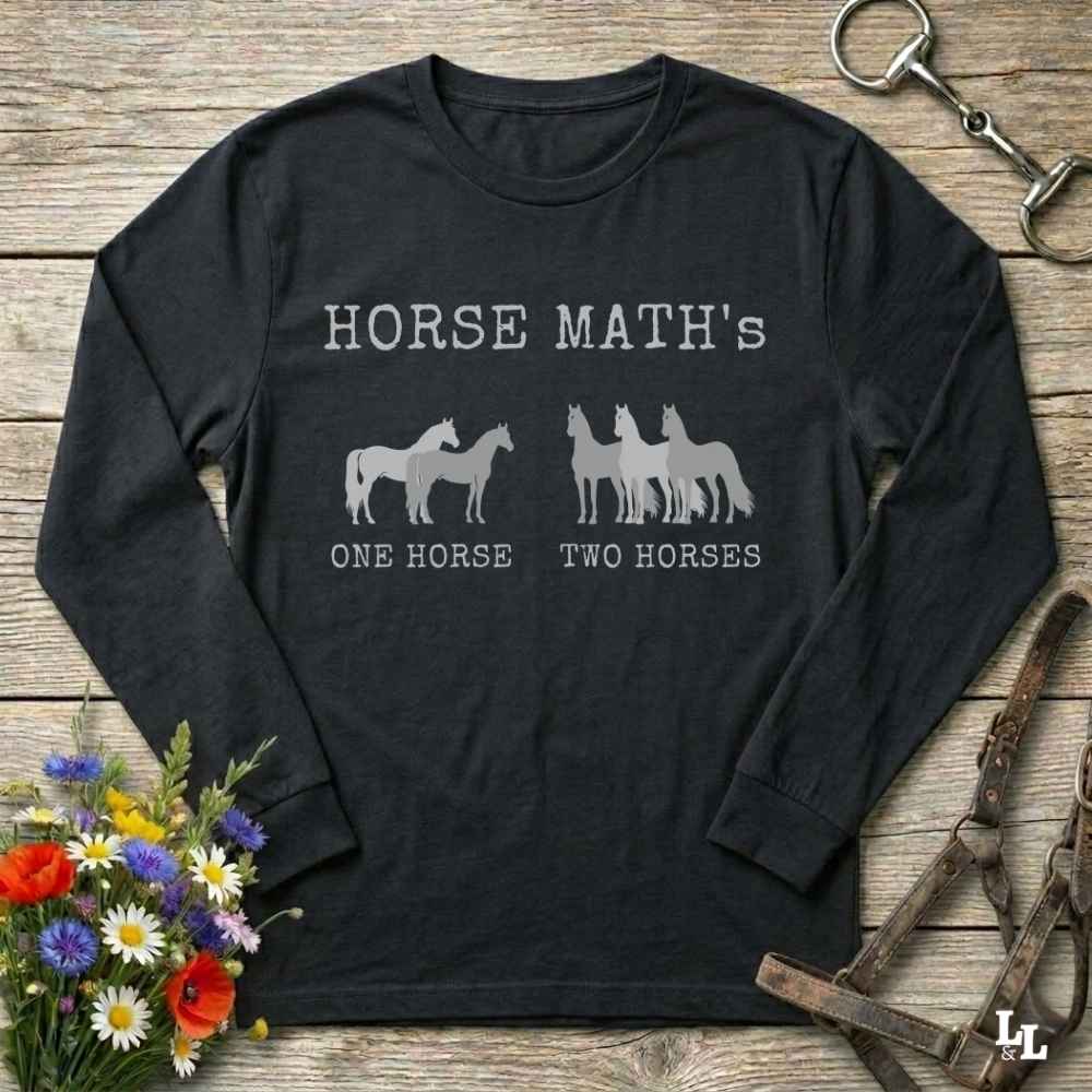 Black long-sleeve shirt with horse-themed text and graphics on a wooden surface with floral and equestrian accessories.