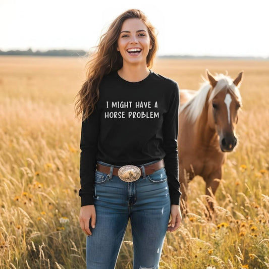 Woman wearing a black sweatshirt with 'I MIGHT HAVE A HORSE PROBLEM' text, standing in a field with a horse. I Might have a Horse Problem Long Sleeve Tee for Horse Lovers, Trail riding Sweatshirt