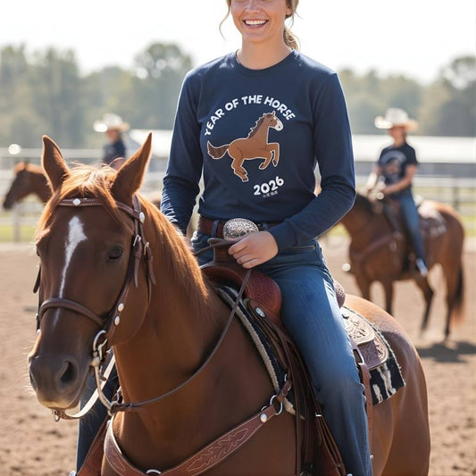 Woman riding a horse wearing a shirt with 'Year of the Horse 2026' design.