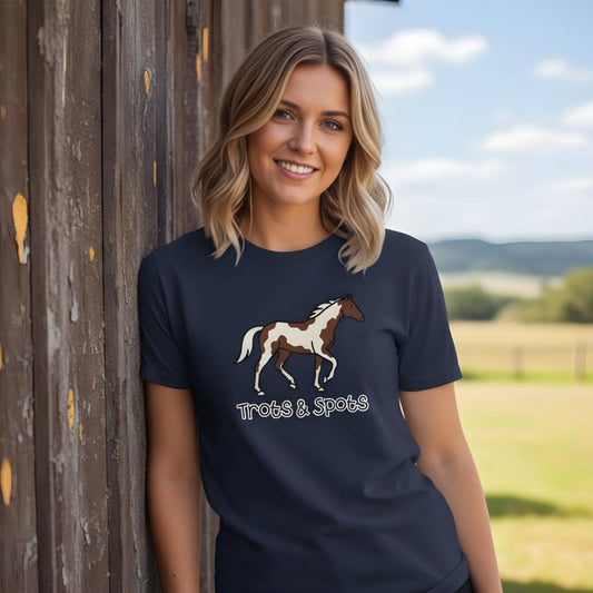 Woman wearing a navy t-shirt with a horse design and 'Trots & Spots' text, standing outdoors. 190 Trots and Spots T-Shirt Trail Riding Tee for Horse Lovers, Equestrian Apparel