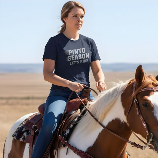 Woman riding a horse in a desert landscape wearing a 'Pinto Season Let's Ride' t-shirt. Pinto Season Let's Ride T-Shirt for Pinto Horse Lovers, Trail Riding Tee