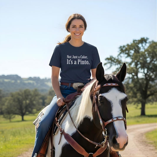 Woman riding a horse in a field wearing a shirt with a message. Not Just a Color T-Shirt for Pinto Horse Lovers, Trail Riding Tee for Horse Riders
