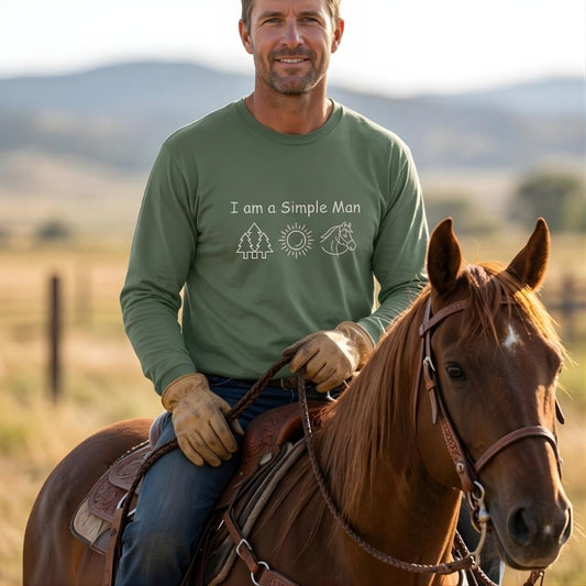 Man riding a horse wearing a green shirt with text and graphics, set against a natural landscape. I am a Simple Man Long Sleeve Tee for Horse Lovers, Trail Riding Tee or Barn Wear