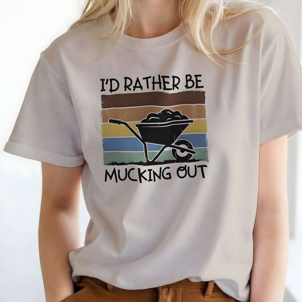 Person wearing a white t-shirt with a graphic and text 'I'd Rather Be Mucking Out' on a plain background.  I'd Rather be Mucking Out T-Shirt for Horse Lovers, Barn Yard Tee, great gift for horse lover