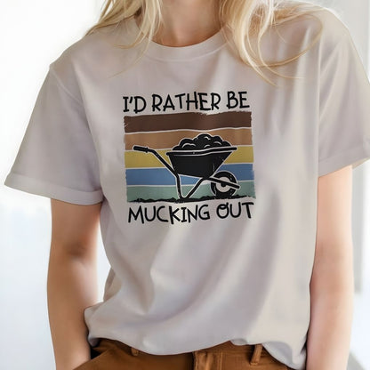 Person wearing a white t-shirt with a graphic and text 'I'd Rather Be Mucking Out' on a plain background.  I'd Rather be Mucking Out T-Shirt for Horse Lovers, Barn Yard Tee, great gift for horse lover