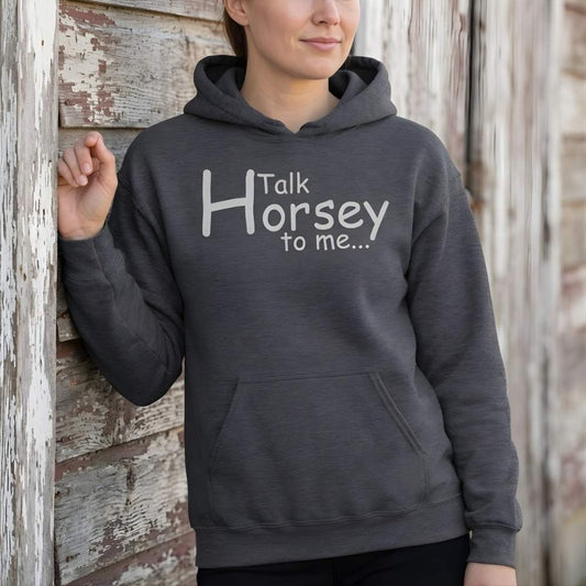 Person wearing a dark gray hoodie with 'Talk Horsey to me...' text against a wooden barn. Talk Horsey to Me Hoodie for Horse Lovers, Cozy Barn Hoodie Equestrian Wear, perfect gift for horse riders, mothers day gift, fathers day gift, Xmas gift